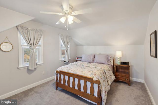 a bedroom with a bed a chandelier and a window