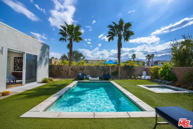 a view of a house with swimming pool and a yard
