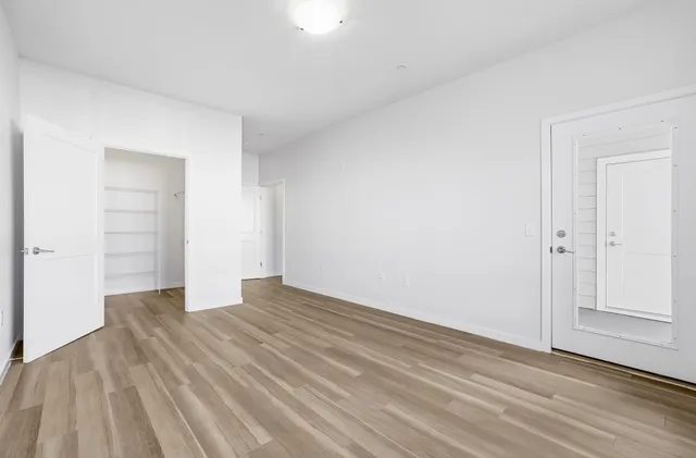 a bedroom with a bed and wooden floor