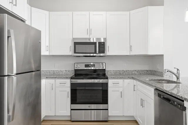 a kitchen with cabinets stainless steel appliances and a sink