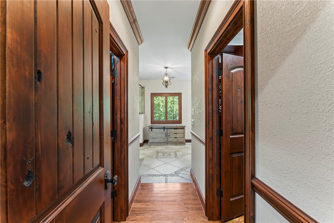 579 Terrapin Crossing Road Pickens, SC 29671 - Photo 17 of 50 Rich hardwood flooring leads to a sun-drenched hallway, featuring knotty alder doors, and intricate tilework