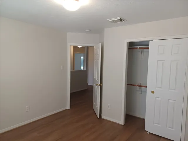 an empty room with wooden floor and closet