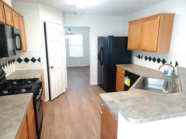 a kitchen with stainless steel appliances granite countertop a refrigerator a stove and a sink