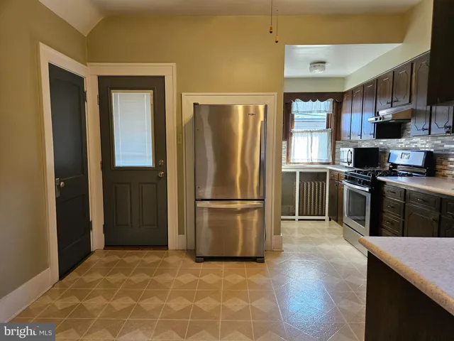 a kitchen with stainless steel appliances granite countertop a refrigerator stove and sink