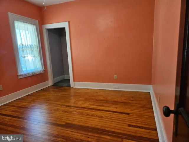 a view of room with window and wooden floor