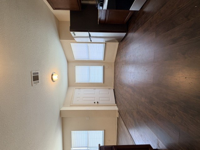 18421 Crestwind Lane Elgin, TX 78621 - Photo 16 of 34 Rich wood-look flooring stretches through this open layout illuminated by natural light.