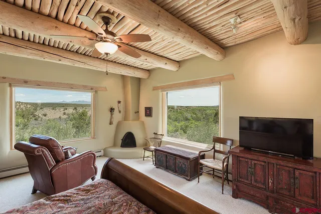 a living room with furniture a flat screen tv and a floor to ceiling window