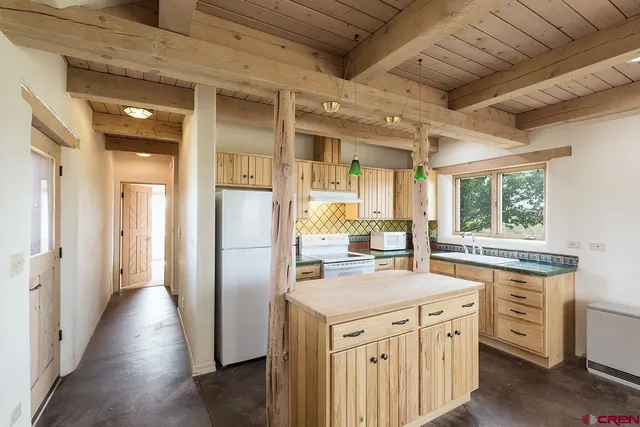 a kitchen with granite countertop a sink stove refrigerator and cabinets