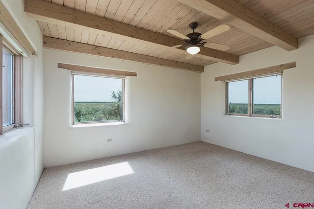 an empty room with a window and a ceiling fan