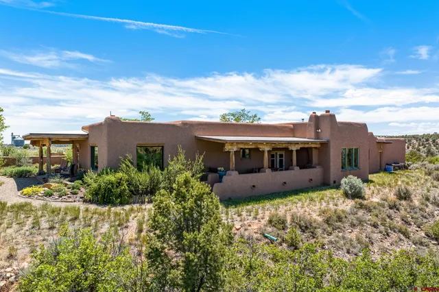a view of a house with a big yard and potted plants