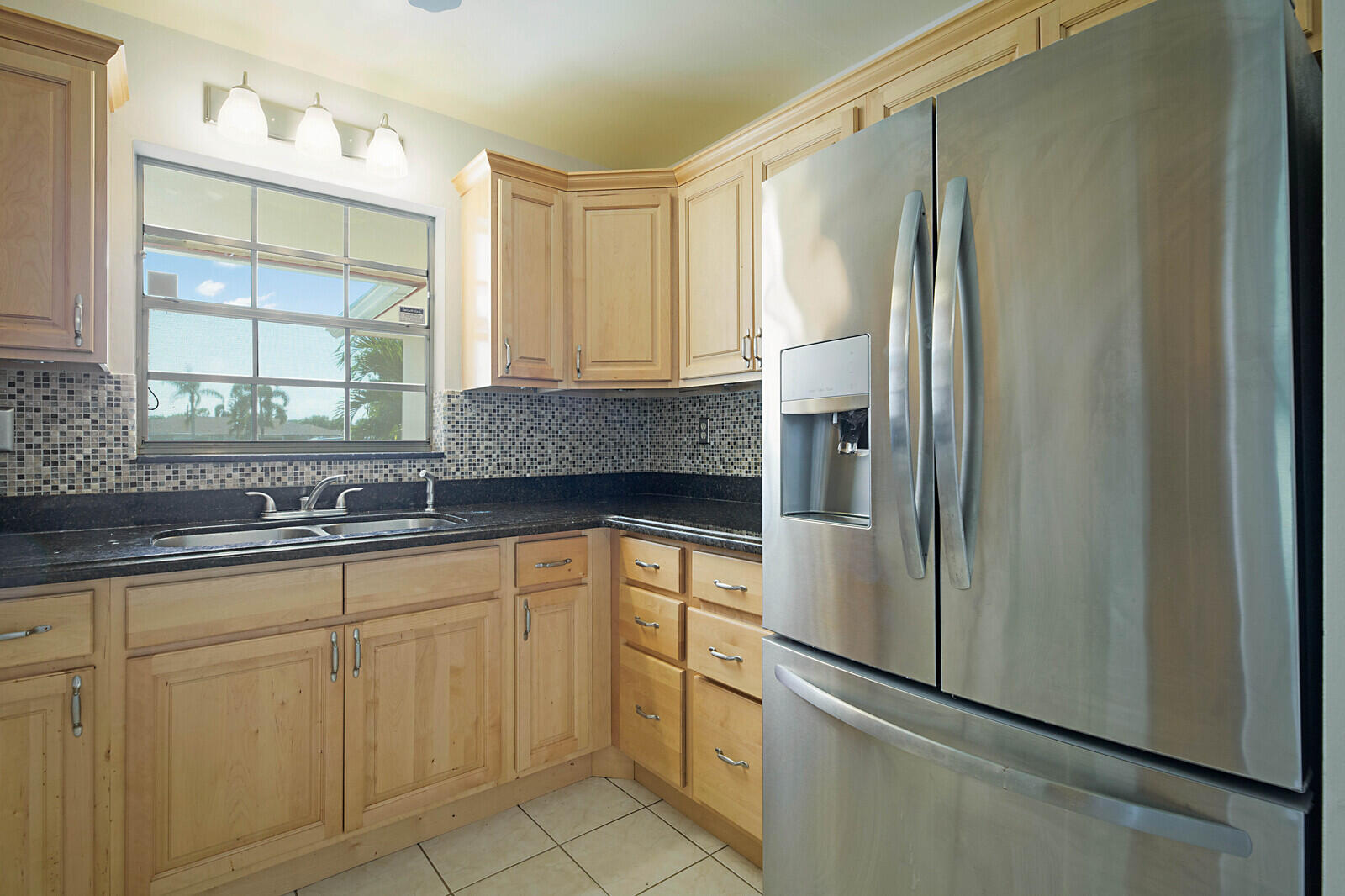 4525 Northwest 3rd Street, Unit D Delray Beach, FL 33445 - Photo 12 of 25 a kitchen with stainless steel appliances granite countertop a refrigerator and a sink