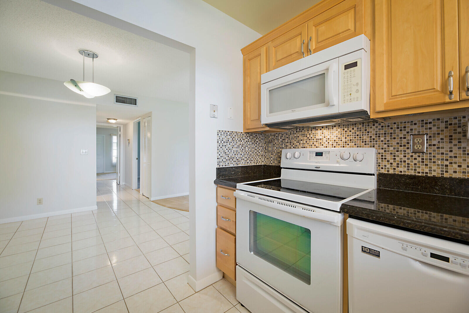4525 Northwest 3rd Street, Unit D Delray Beach, FL 33445 - Photo 14 of 25 a kitchen with granite countertop a stove top oven microwave and cabinets