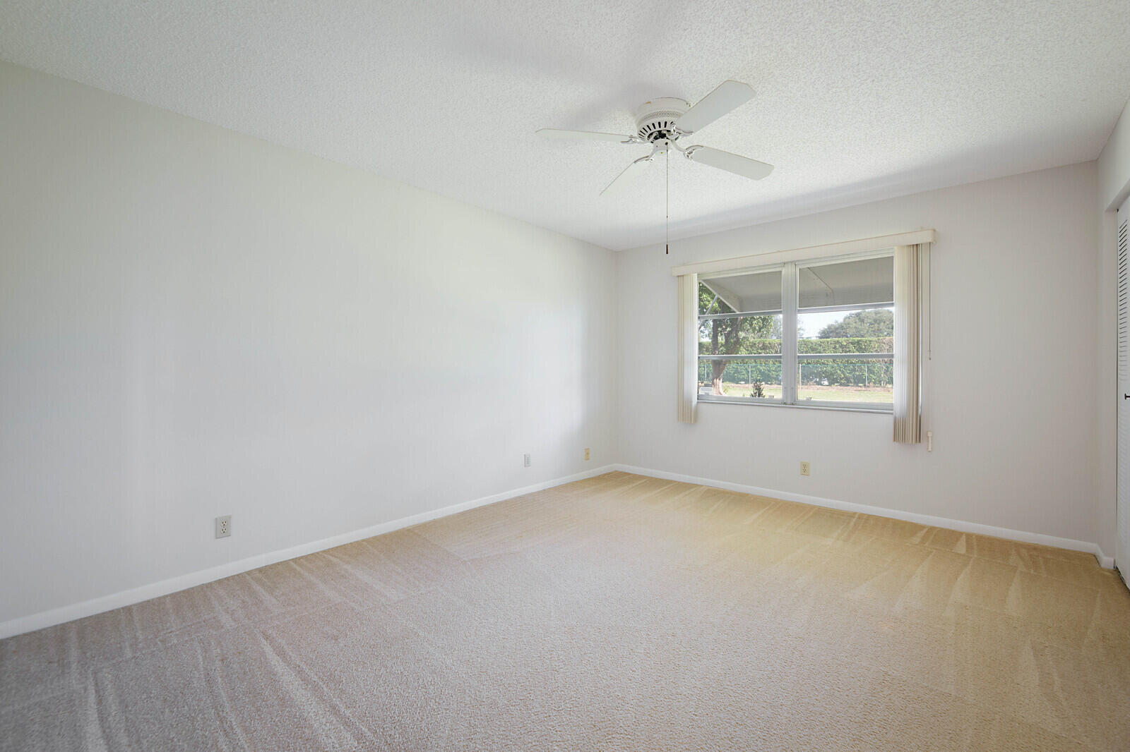 4525 Northwest 3rd Street, Unit D Delray Beach, FL 33445 - Photo 15 of 25 an empty room with a window and ceiling fan