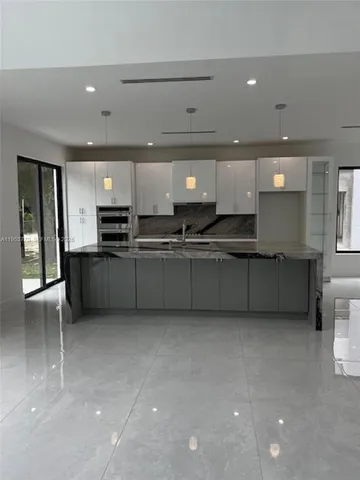 a large kitchen with stainless steel appliances a sink and a cabinets