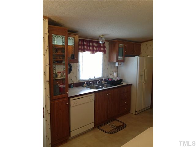 206 West O Painter Road Timberlake, NC 27583 - Photo 11 of 16 a kitchen with stainless steel appliances granite countertop a sink and a refrigerator