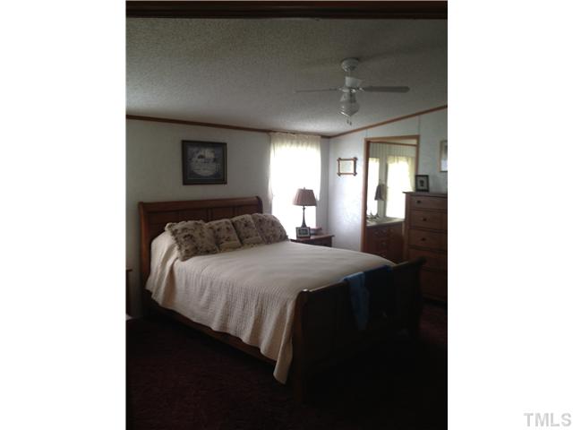 206 West O Painter Road Timberlake, NC 27583 - Photo 13 of 16 a bedroom with a bed and a mirror