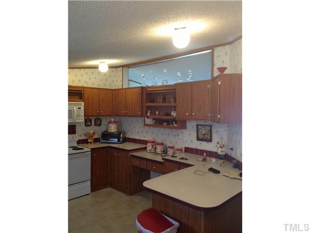 206 West O Painter Road Timberlake, NC 27583 - Photo 9 of 16 a kitchen with a sink a stove and chairs