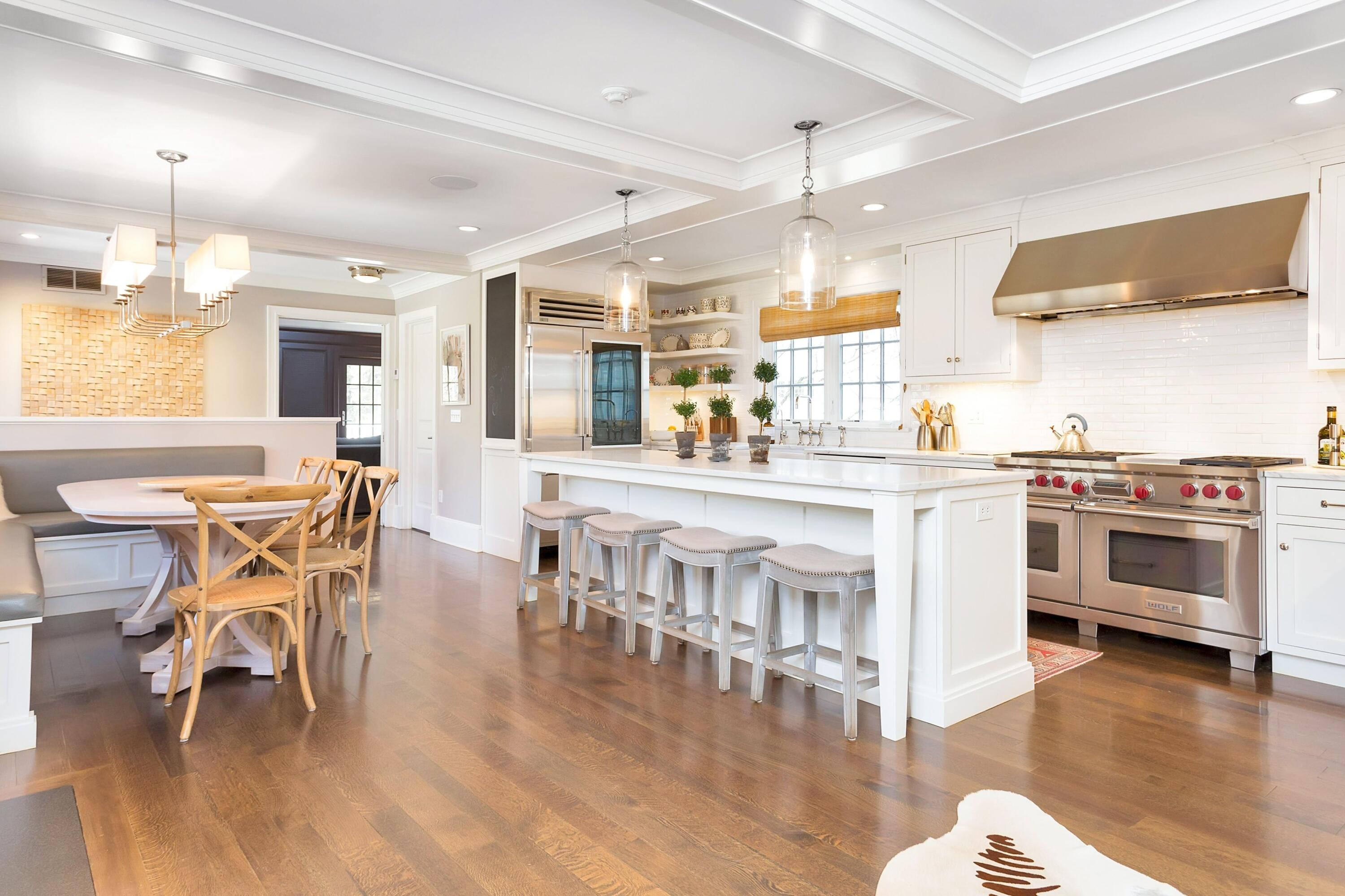 343-335 Wahackme Road New Canaan, CT 06840 - Photo 12 of 32 a kitchen with stainless steel appliances granite countertop a stove top oven a sink a dining table and chairs with wooden floor