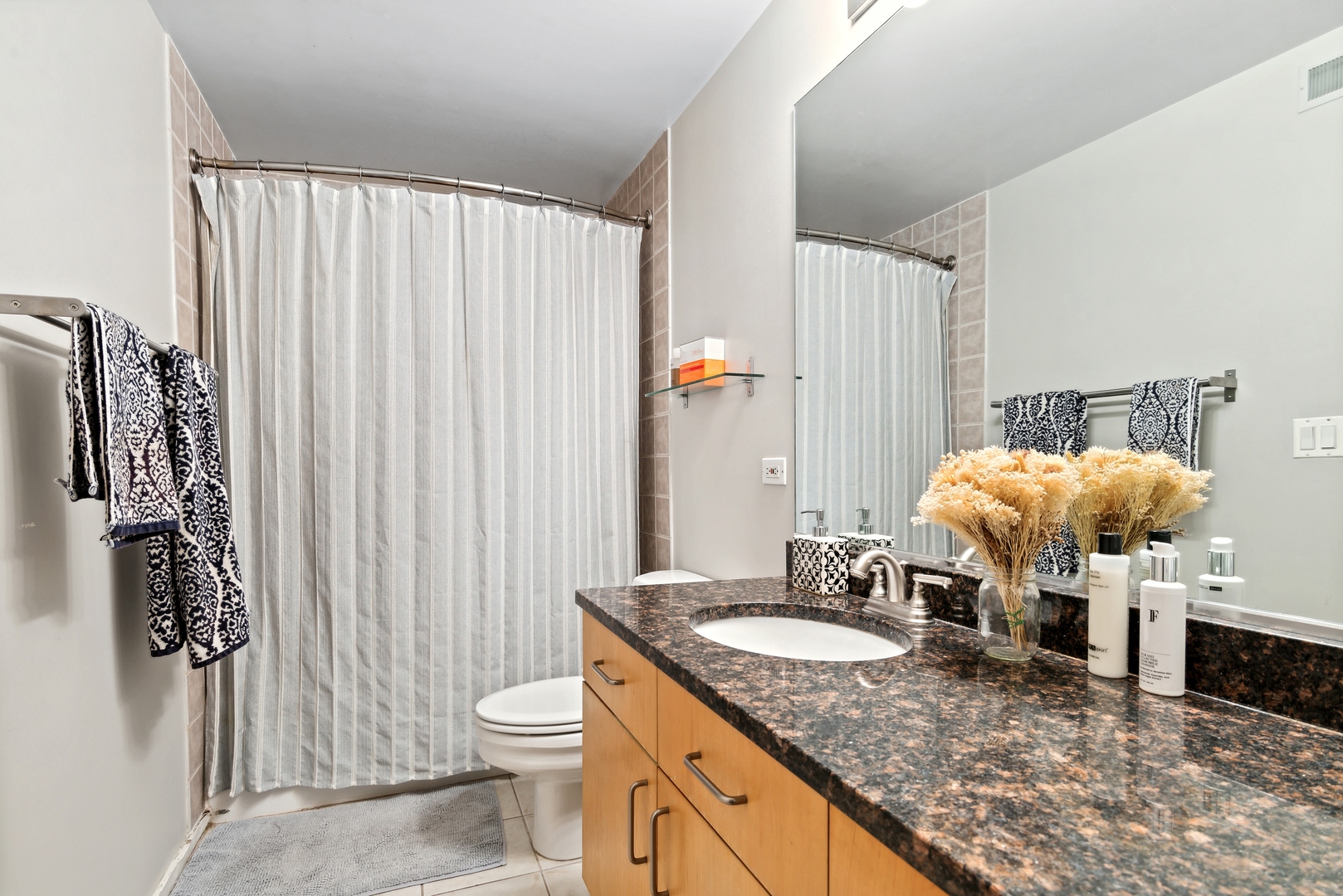843 West Adams Street, Unit 405 Chicago, IL 60607 - Photo 10 of 12 a bathroom with a granite countertop sink and a mirror