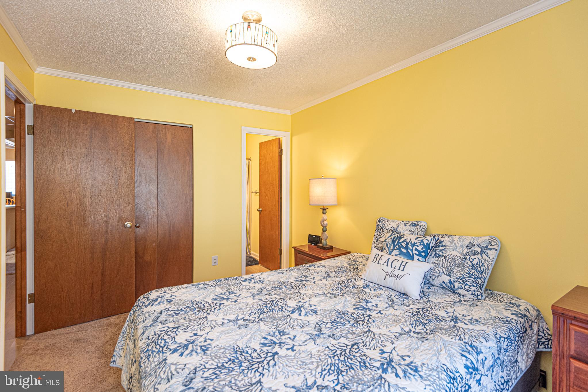 14405 Tunnel Avenue, Unit 112 Ocean City, MD 21842 - Photo 17 of 32 a bedroom with a bed and a chandelier