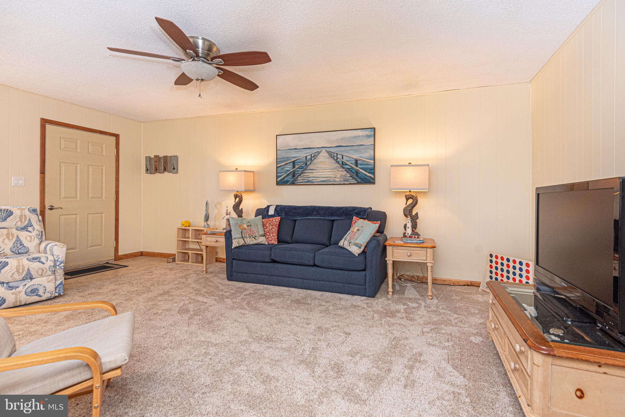 14405 Tunnel Avenue, Unit 112 Ocean City, MD 21842 - Photo 27 of 32 a living room with furniture and a flat screen tv