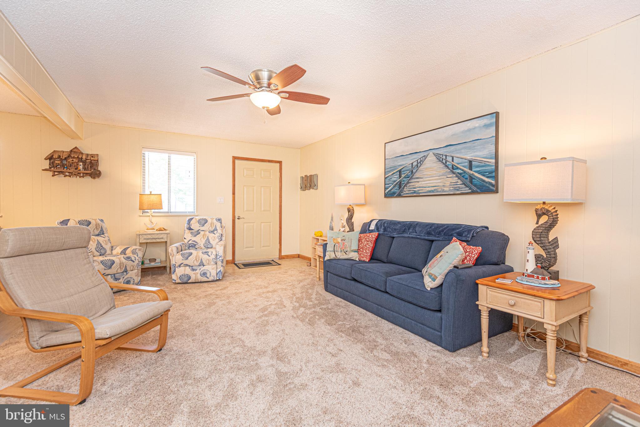 14405 Tunnel Avenue, Unit 112 Ocean City, MD 21842 - Photo 28 of 32 a living room with furniture and a chandelier