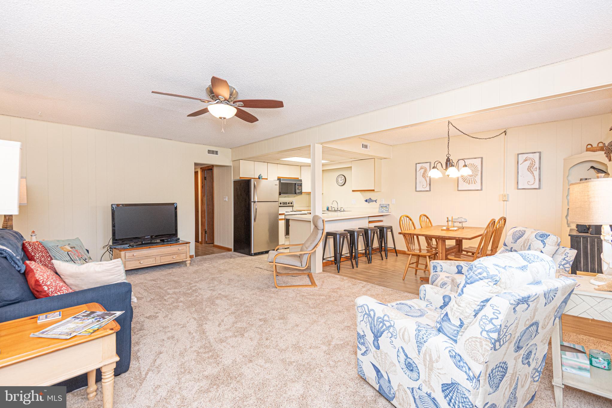 14405 Tunnel Avenue, Unit 112 Ocean City, MD 21842 - Photo 4 of 32 a living room filled with furniture and a flat screen tv