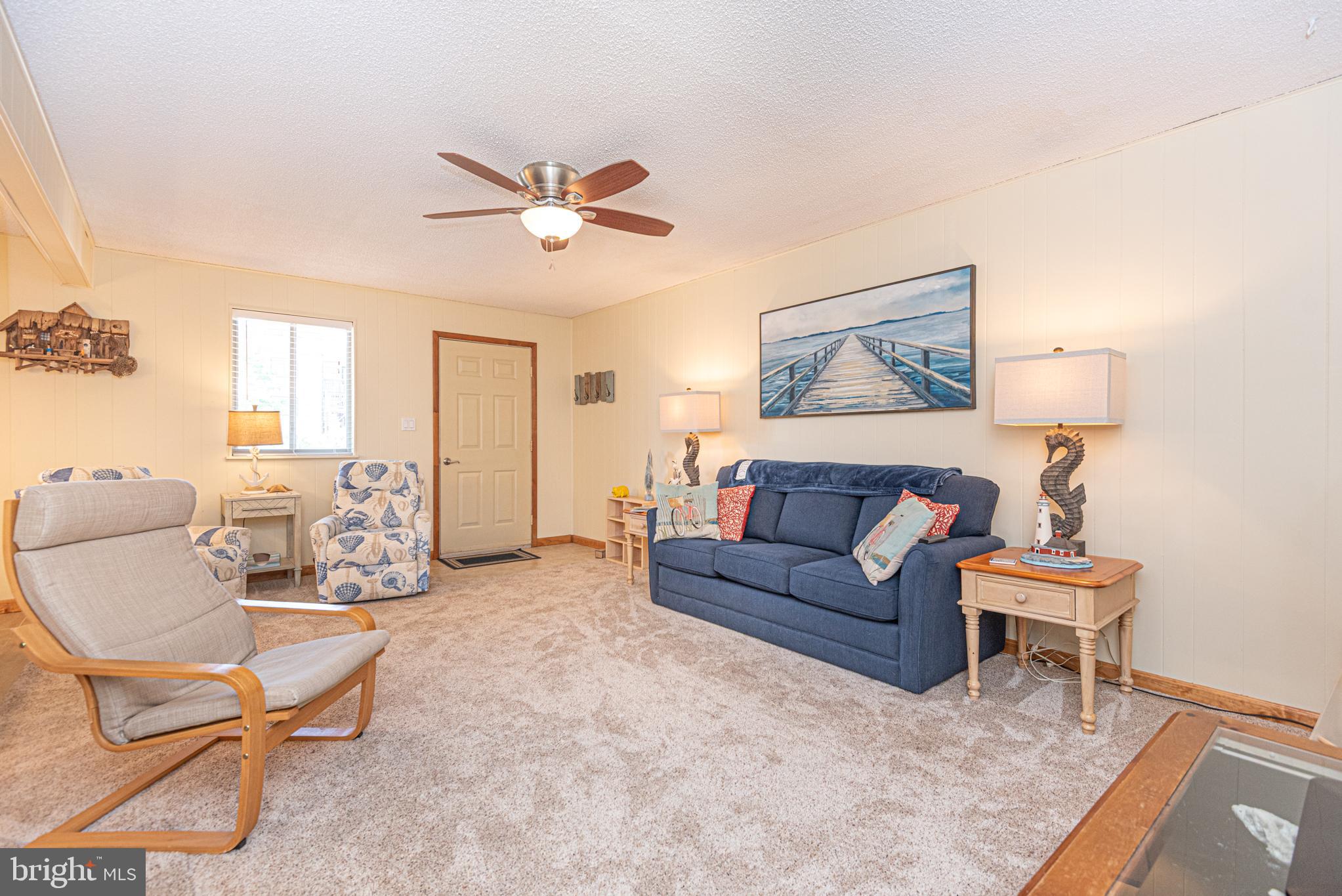 14405 Tunnel Avenue, Unit 112 Ocean City, MD 21842 - Photo 5 of 32 a living room with furniture and a chandelier