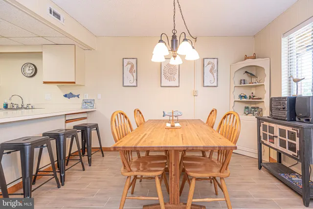 a view of a dining room with furniture a chandelier and wooden floor