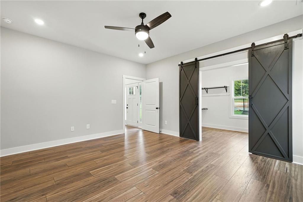 133 Old Alabama Road Southeast Emerson, GA 30137 - Photo 4 of 40 a view of an empty room with wooden floor and a ceiling fan