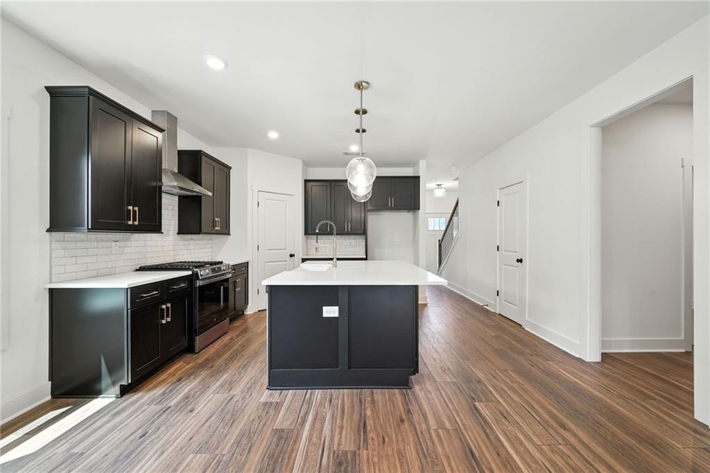 133 Old Alabama Road Southeast Emerson, GA 30137 - Photo 6 of 40 a large kitchen with granite countertop a large counter top space stainless steel appliances and wooden floor