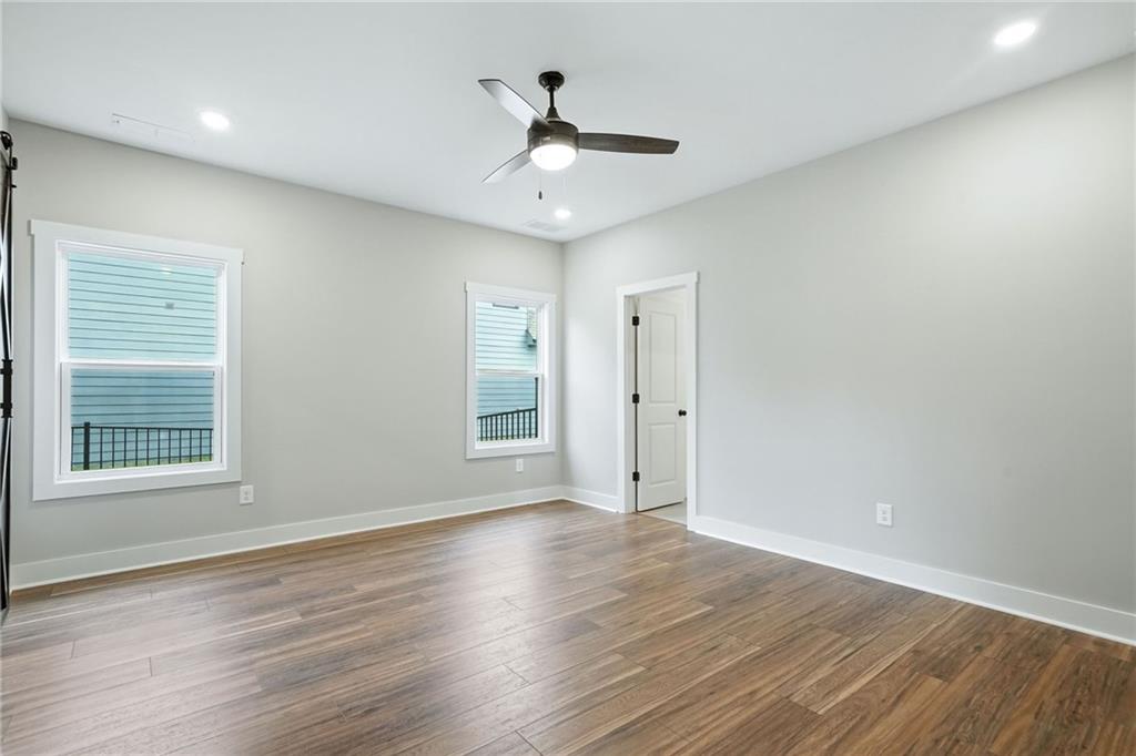 133 Old Alabama Road Southeast Emerson, GA 30137 - Photo 7 of 40 an empty room with wooden floor chandelier fan and windows