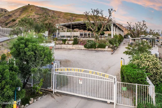 a view of a house with a small yard and wooden fence