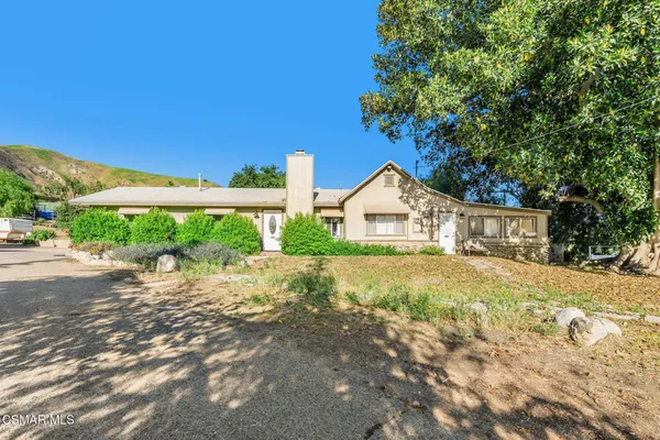 a white house that has a tree in front of it