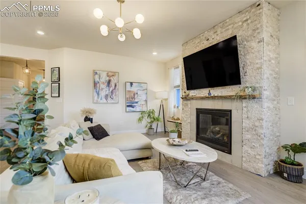 a living room with furniture kitchen and a chandelier