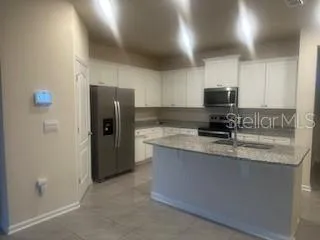 a kitchen with stainless steel appliances granite countertop a refrigerator a stove a sink and a granite counter tops