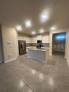 163 Redbud Road Palm Coast, FL 32137 - Photo 4 of 29 a large kitchen with stainless steel appliances a refrigerator and a stove top oven