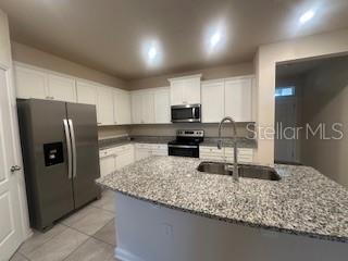 163 Redbud Road Palm Coast, FL 32137 - Photo 5 of 29 a kitchen with stainless steel appliances granite countertop a sink refrigerator and microwave