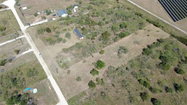 a view of a field with trees in background