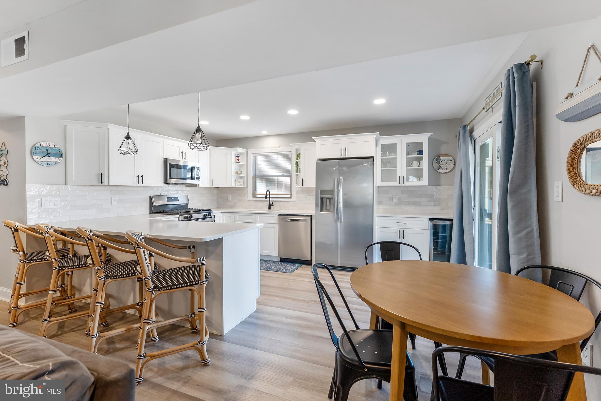 12 Lighthouse Drive, Unit A Brigantine, NJ 08203 - Photo 11 of 32 a kitchen with stainless steel appliances granite countertop a dining table chairs refrigerator and cabinets