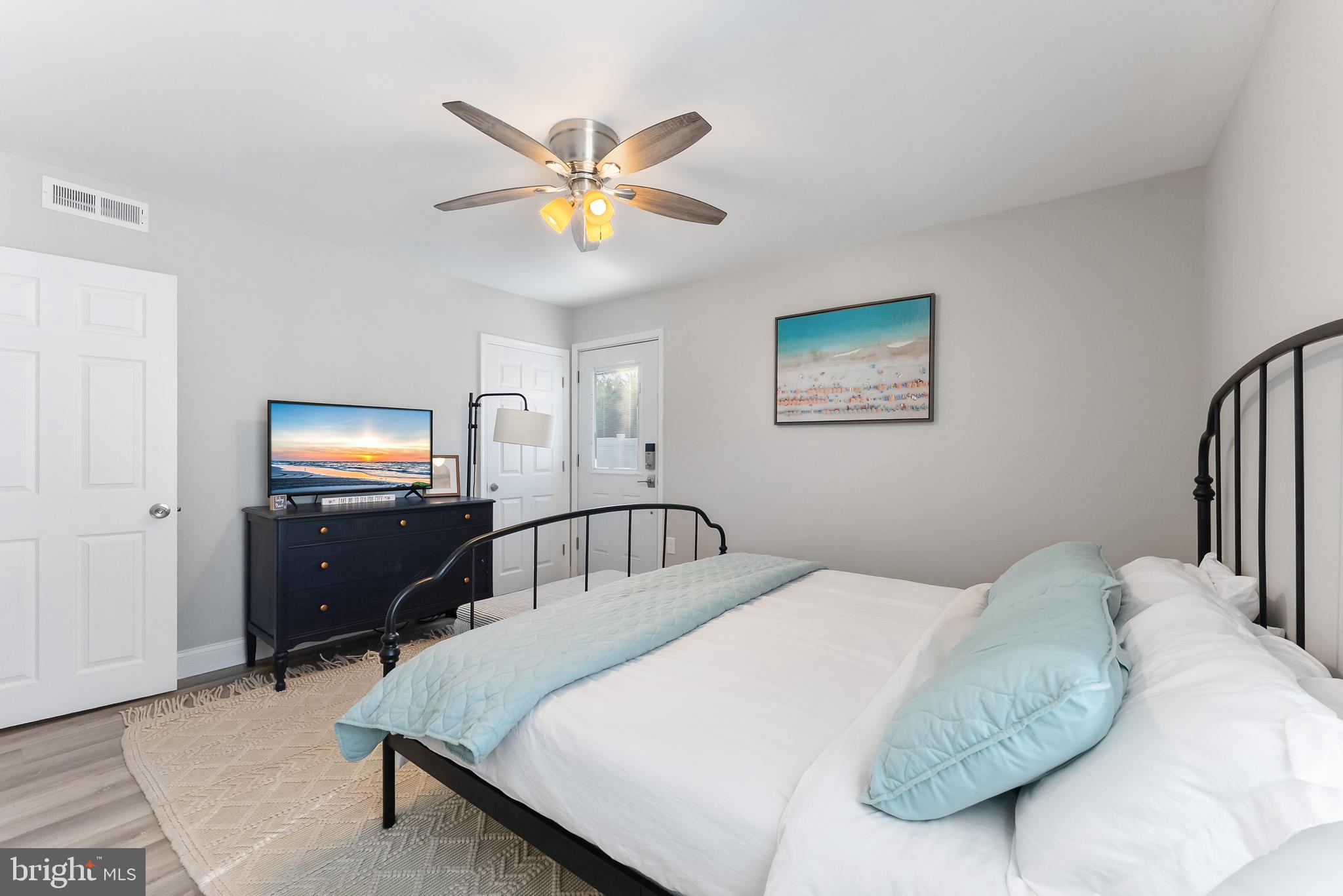 12 Lighthouse Drive, Unit A Brigantine, NJ 08203 - Photo 18 of 32 a bedroom with a bed and a lamp on dresser