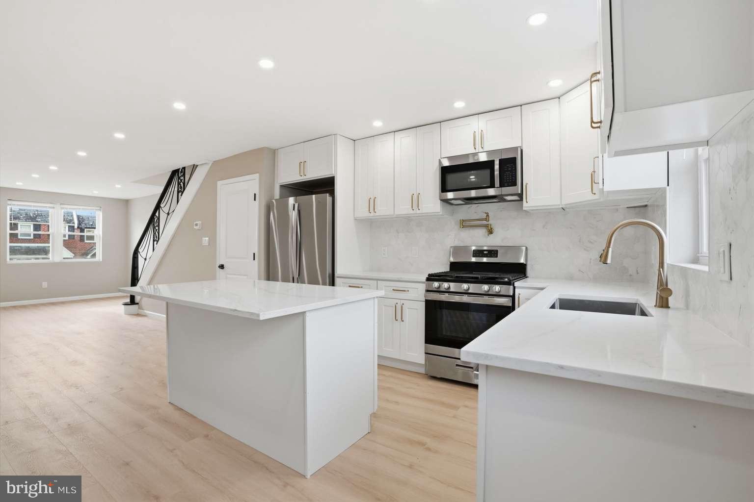 8653 Rugby Street Philadelphia, PA 19150 - Photo 15 of 45 a kitchen with stainless steel appliances a stove sink microwave and cabinets