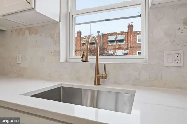 a kitchen with a sink and large mirror