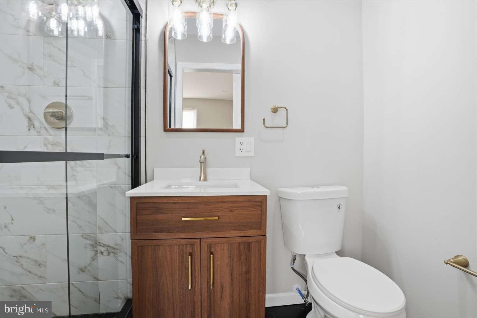 8653 Rugby Street Philadelphia, PA 19150 - Photo 23 of 45 a bathroom with a granite countertop toilet sink and mirror