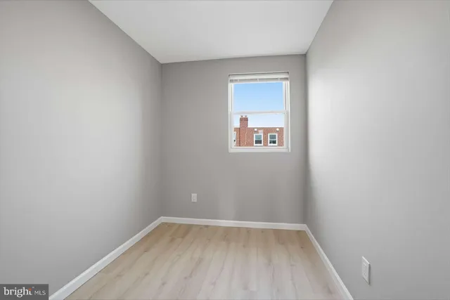 a view of a small space with wooden floor and a window