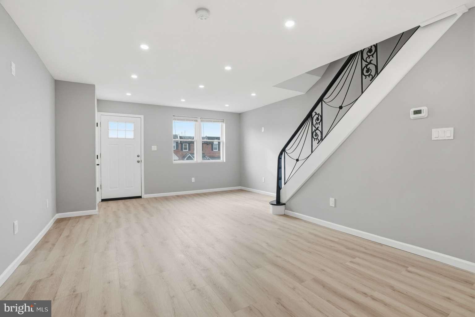 8653 Rugby Street Philadelphia, PA 19150 - Photo 6 of 45 a view of an empty room with wooden floor and stairs