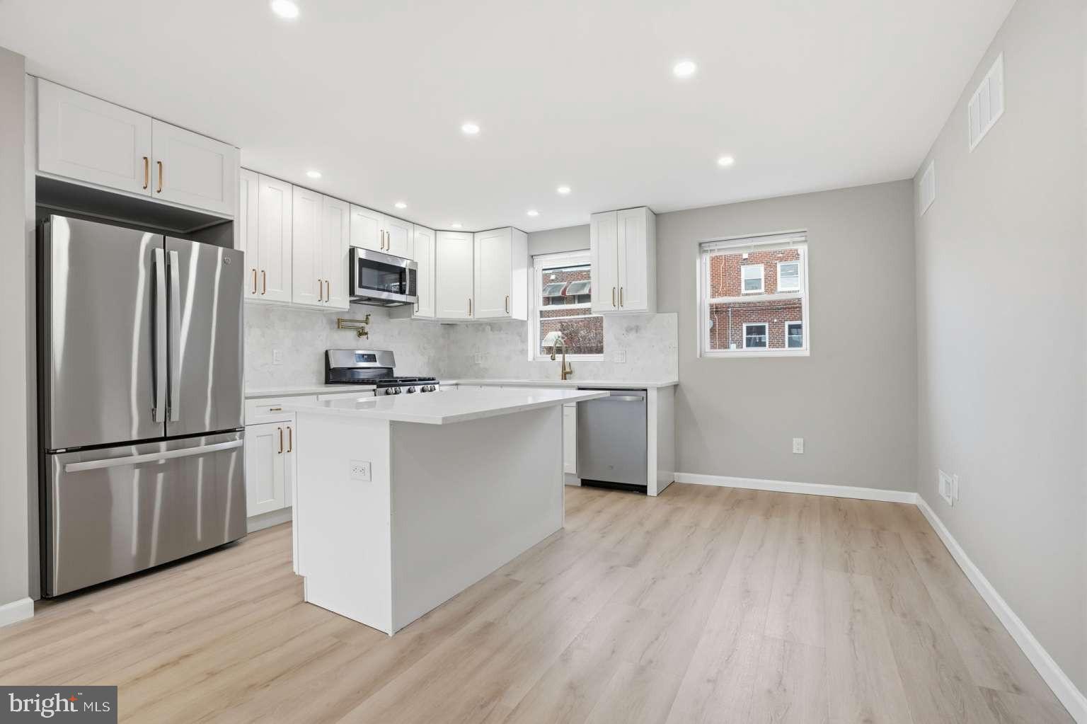 8653 Rugby Street Philadelphia, PA 19150 - Photo 7 of 45 a kitchen with a refrigerator a sink and cabinets