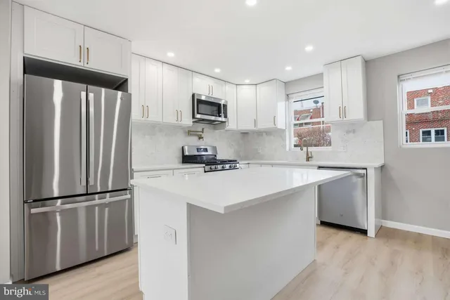 a kitchen with stainless steel appliances a refrigerator sink and microwave