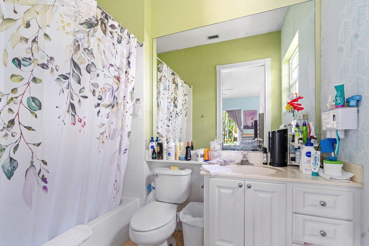 7580 Red River Road West Palm Beach, FL 33411 - Photo 27 of 69 a bathroom with a sink a toilet and a large mirror