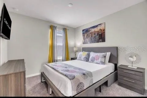 a bedroom with a bed and a flat screen tv